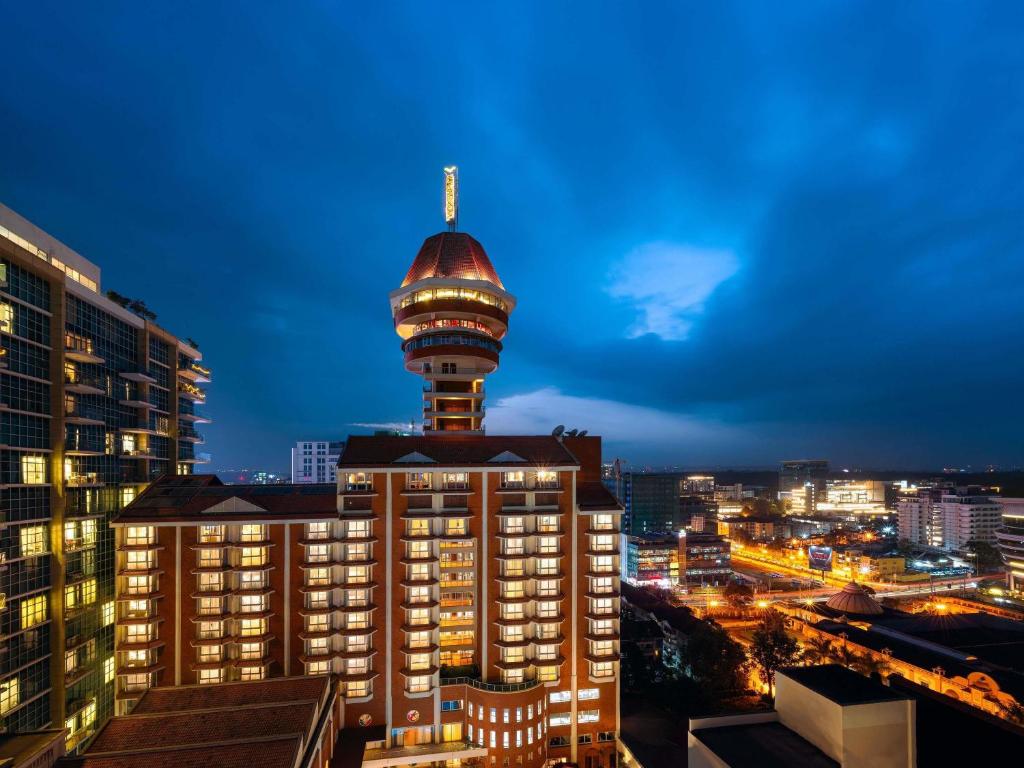 a building with a tower on top of it at night at Mövenpick Hotel & Residences Nairobi in Nairobi
