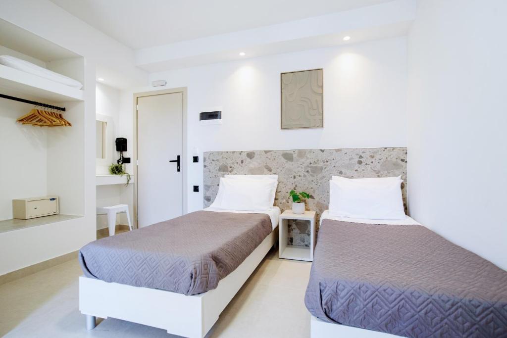two beds in a room with white walls at Seaside Resorts in Kavos