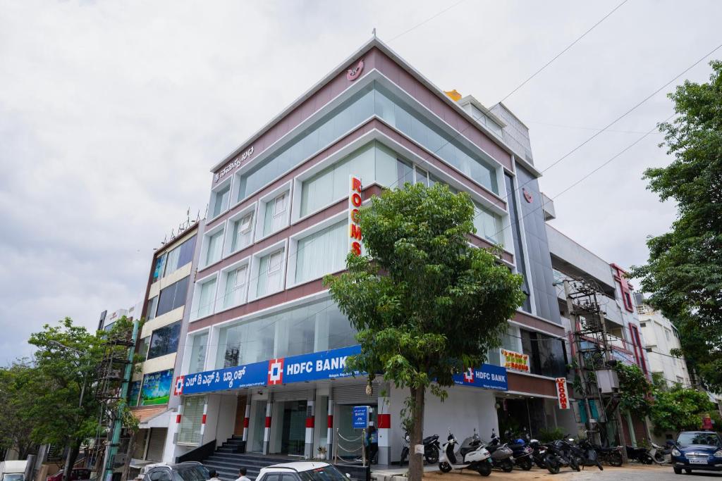 a building with a tree in front of it at Sri Sai Lotus In in Bangalore