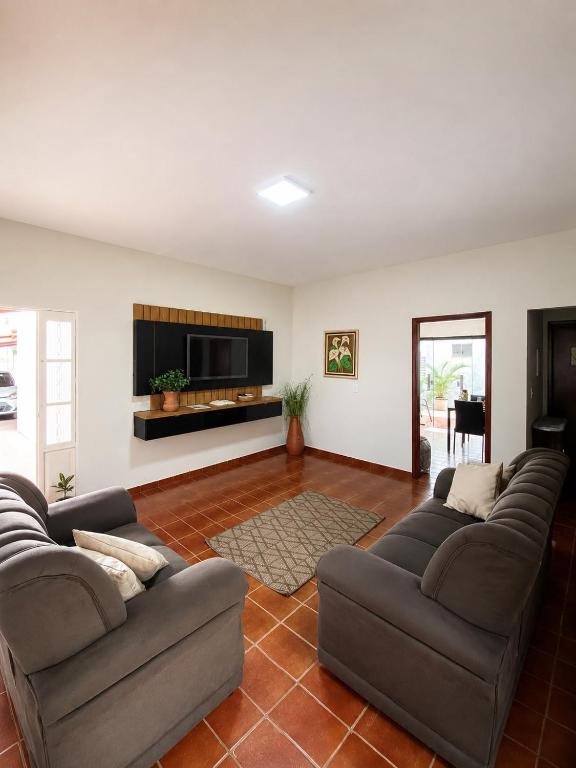 a living room with two couches and a flat screen tv at Casa Temporada Espaço Vip in Barra do Garças