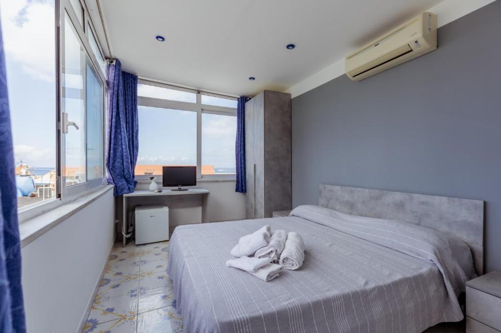 a bedroom with a bed with towels on it at Casamicciola Rooms in Casamicciola Terme