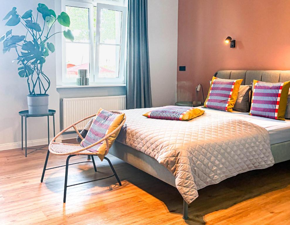 a bedroom with a bed with colorful pillows and a chair at Studios am Hafen in Stralsund