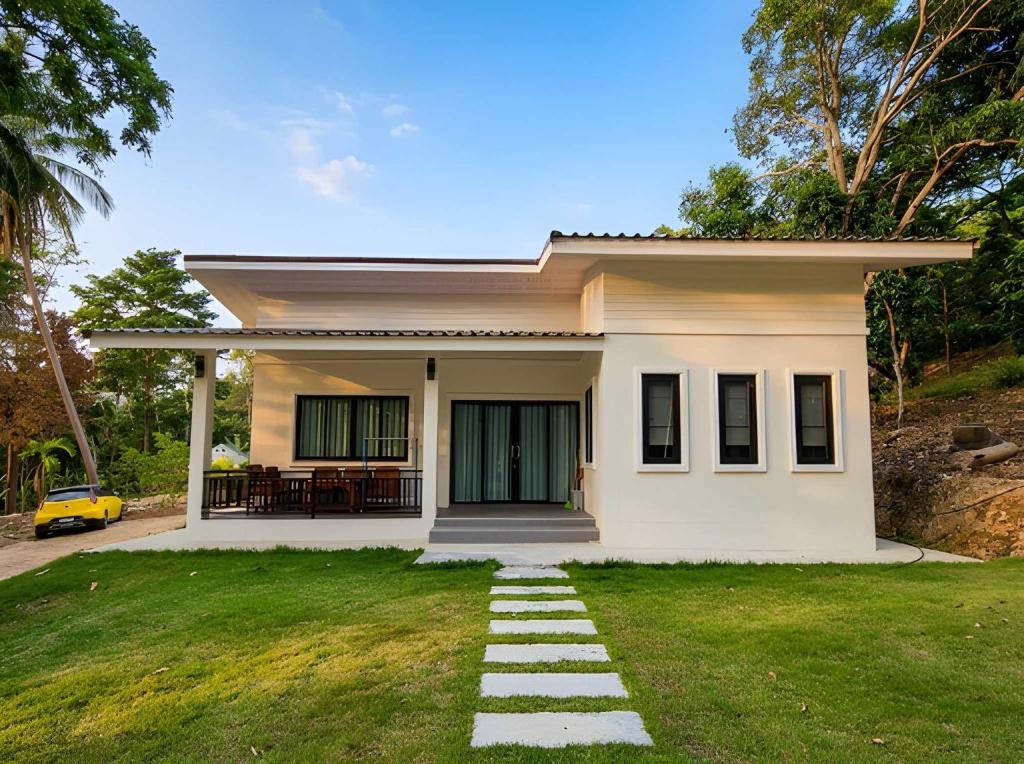 a small house with a green lawn in front of it at Soul House - Stay Beautifully in Ko Kong Nui