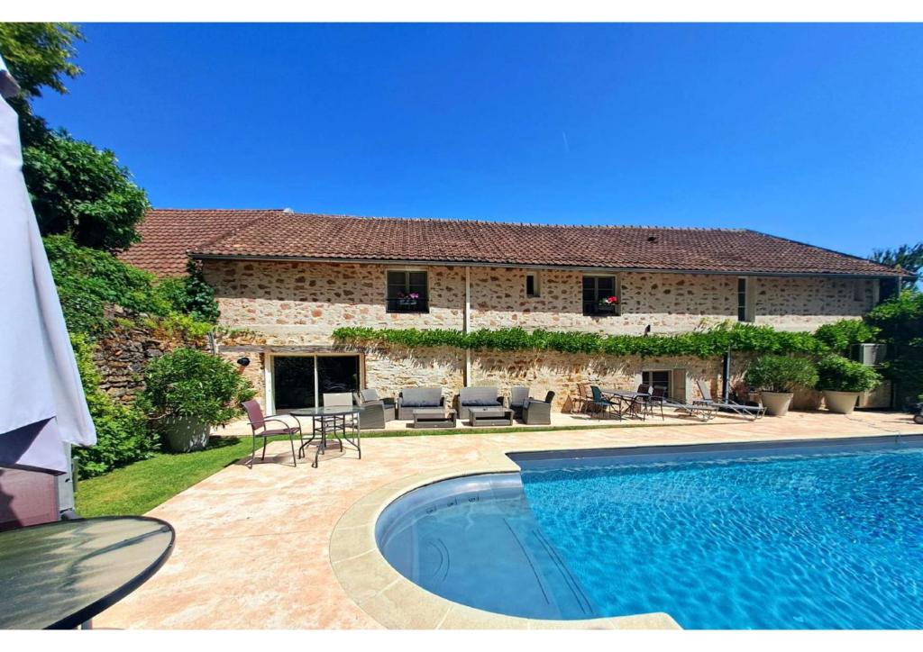 a house with a swimming pool in front of it at Clos De La Gourmandière, Maison d'hôtes & Restaurant in Saint-Lothain