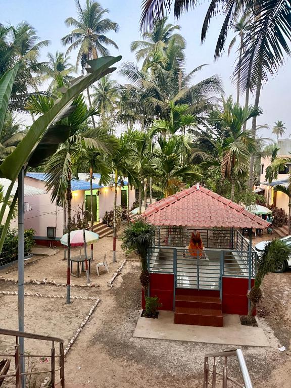 a house on the beach with palm trees at Sai beach Resort in Diveagar