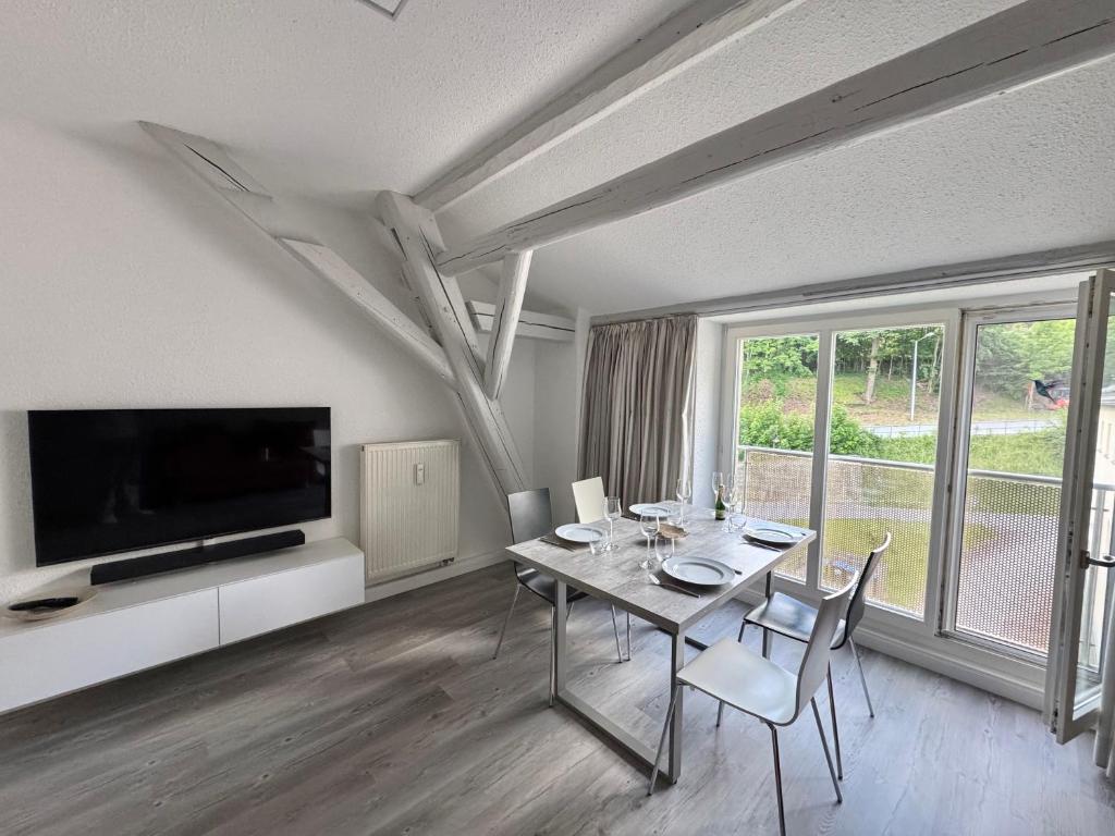 a dining room with a table with chairs and a television at Brauhaus Suite 20 in Sebnitz