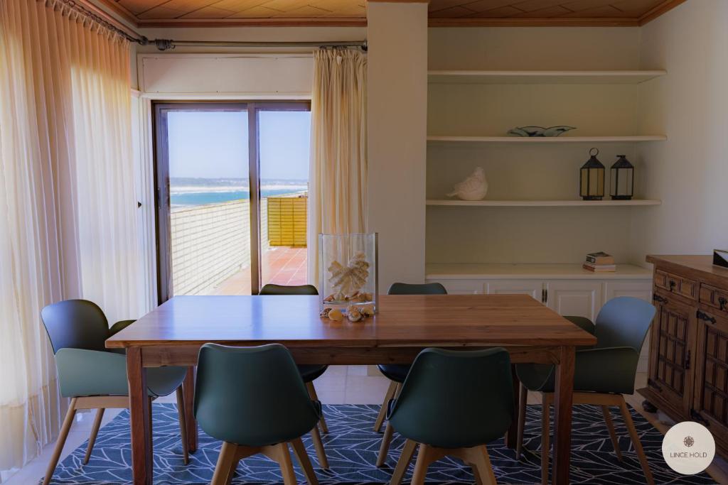 a dining room with a table and chairs and the ocean at Apartamento Ruy Belo - Foz in Vila do Conde