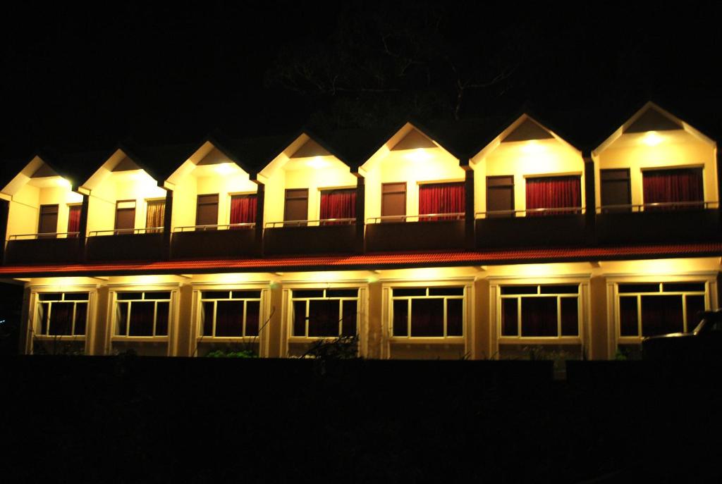 a lit up building at night with lights at Hotel sunrise in Kodaikānāl