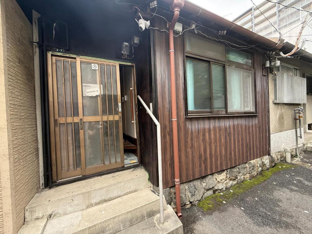 an entrance to a house with a door and stairs at HANA88のa,b in Otsu