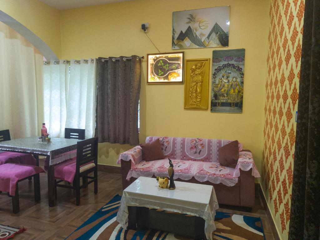 a living room with a couch and a table at Bhakti Suite in Deoghar