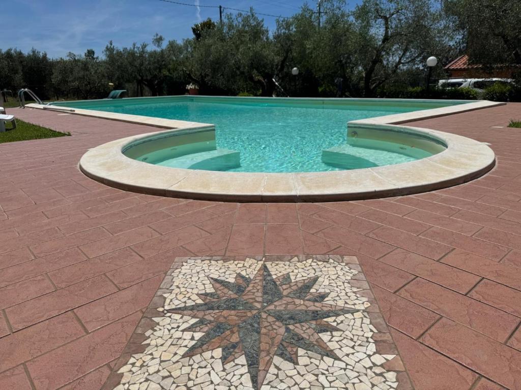 a swimming pool with a star on the ground at Le Coccole Del Trasimeno in Tuoro sul Trasimeno