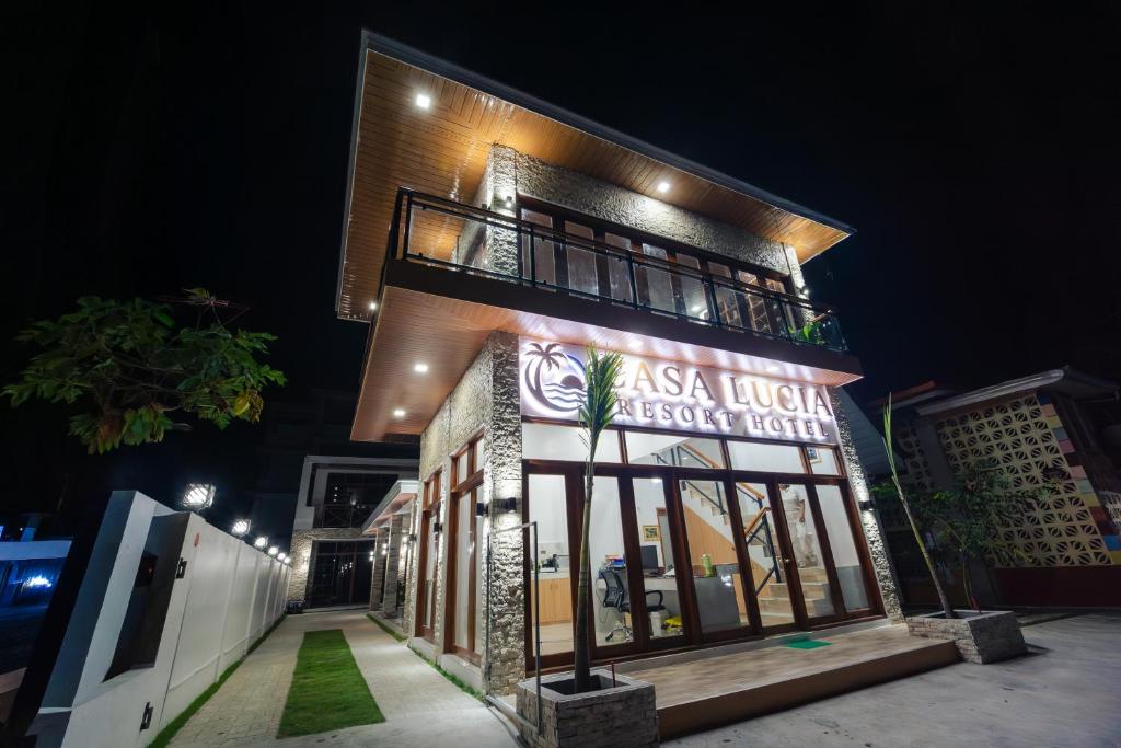 a building with a sign on it at night at Casa Lucia Resort Hotel in Oslob