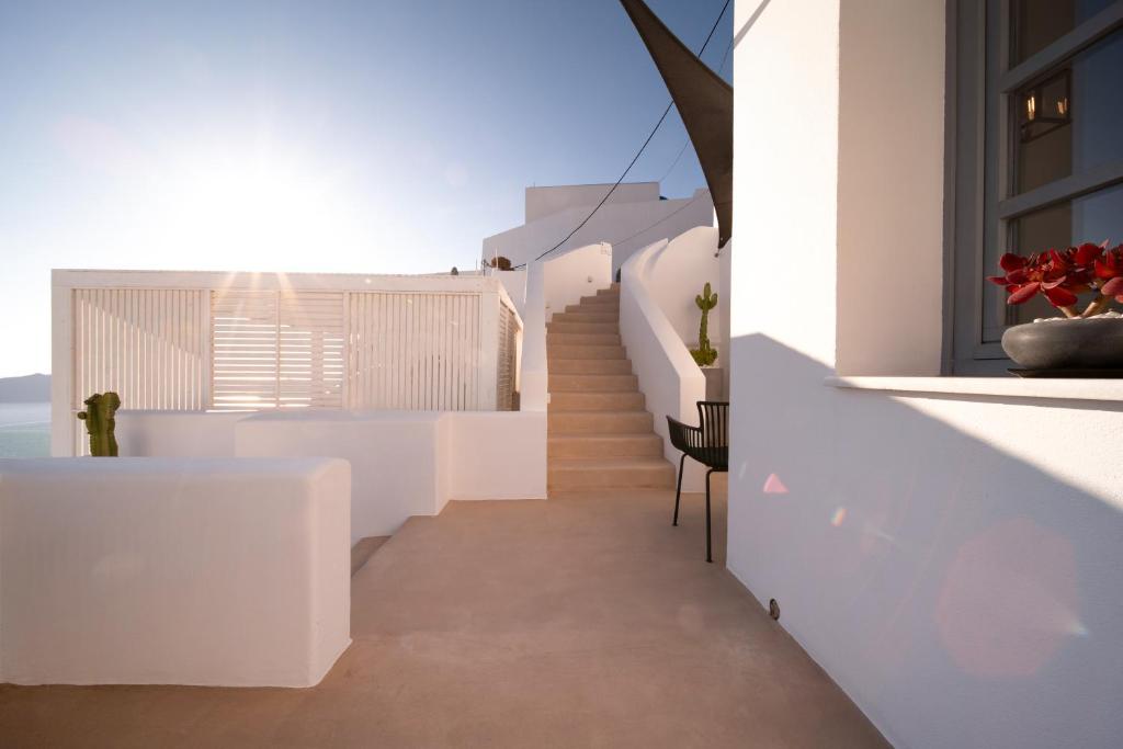 a staircase in a white house with a view of the ocean at Imera Vista Suites in Imerovigli