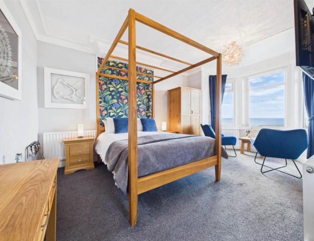 a bedroom with a canopy bed and a desk at The Fossil Tree Hotel in Blackpool
