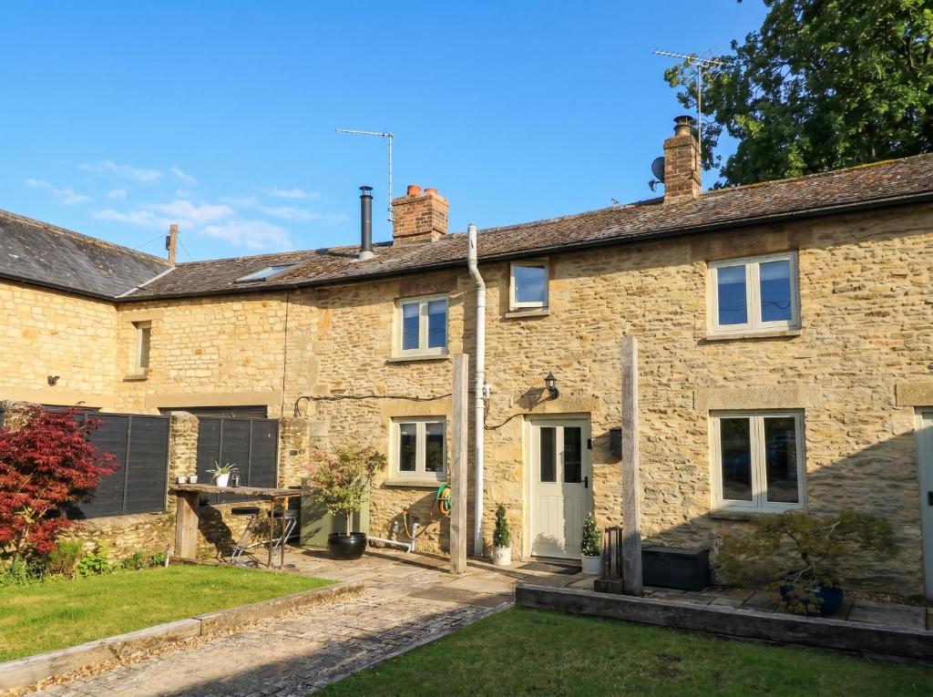 an old stone house with a garden in front of it at 2 The Gardens in Lechlade