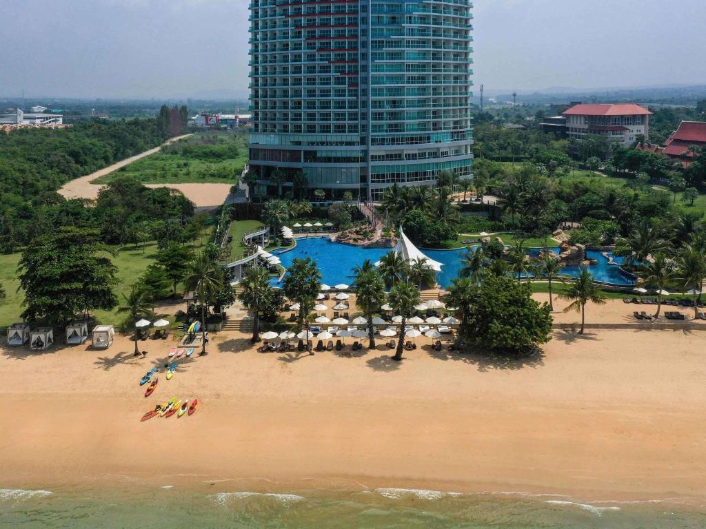 an aerial view of a resort with a beach and a building at Mövenpick Siam Hotel Na Jomtien Pattaya in Na Jomtien