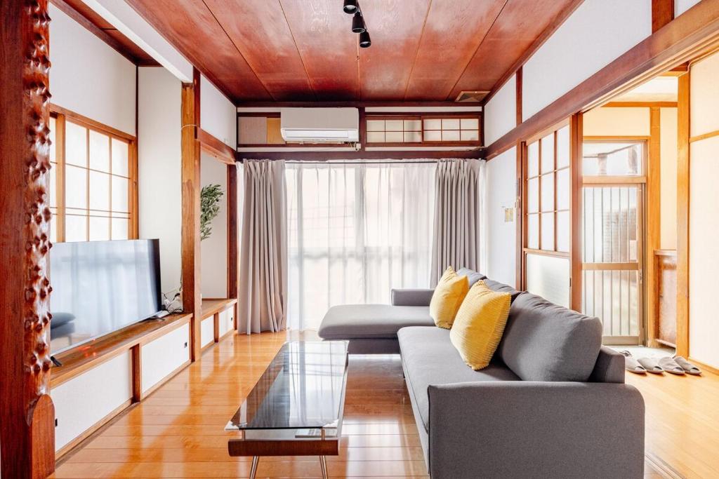 a living room with a couch and a tv at AO Niigata in Niigata