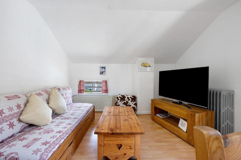 a living room with a couch and a flat screen tv at Appartement Aime La Plagne in Aime-La Plagne