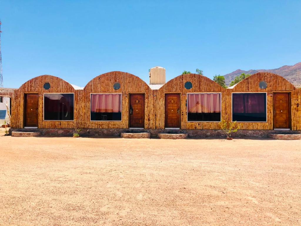 a wooden building in the middle of a desert at Reef Beach Camp in Nuweiba