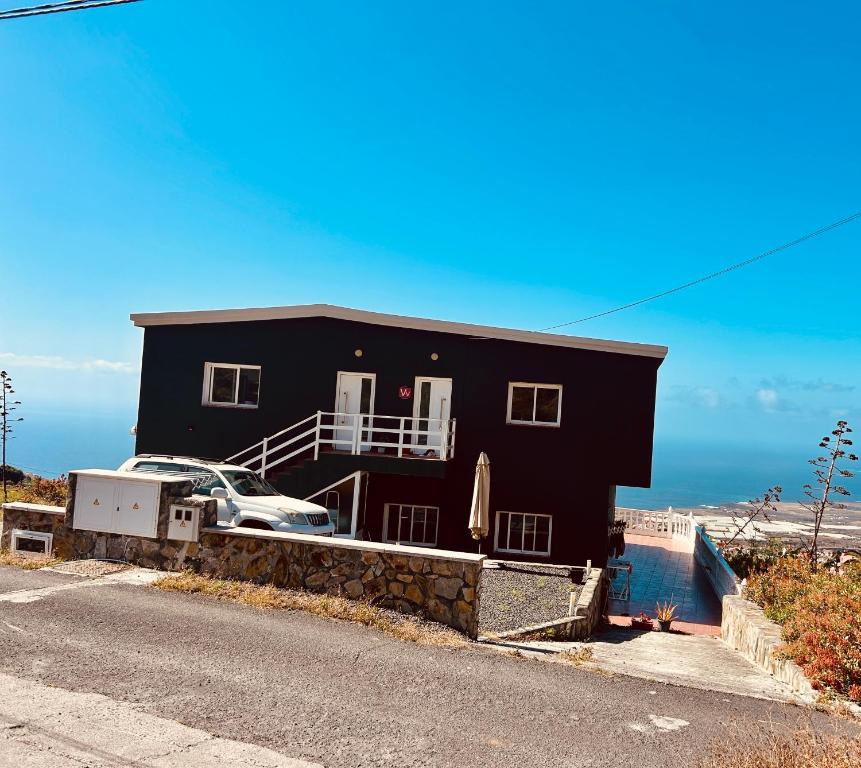a black house with a car parked in front of it at Vista Guapa in Frontera