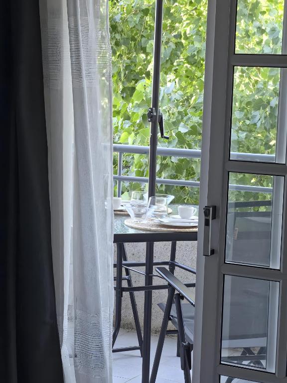 an open door to a patio with a table and a window at Garça-Real 2 in Vale de Madeiros