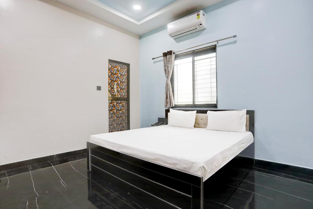 a bedroom with a bed in a room at Hotel O Raj Guest House in Akola