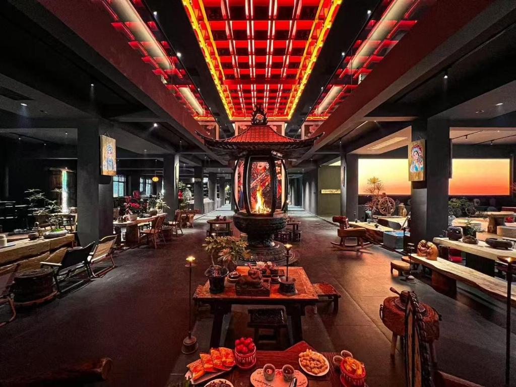 a restaurant with tables and chairs and a large chandelier at Wuzhen FortuneCourt Hotel in Jiaxing