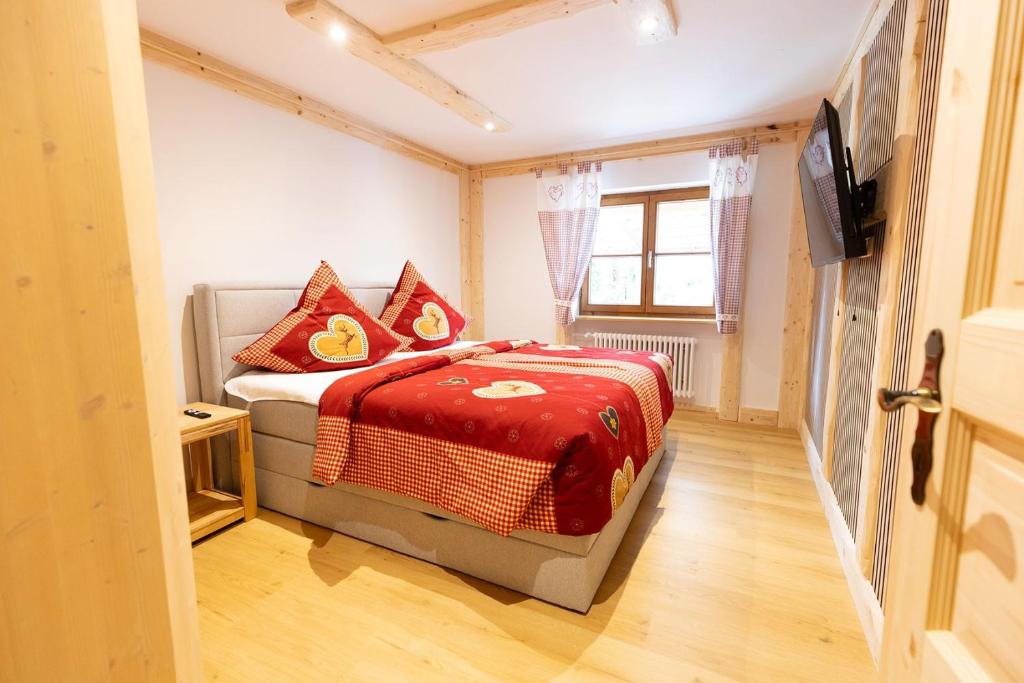 a bedroom with a bed with a red blanket at Chalet Au in Fischen
