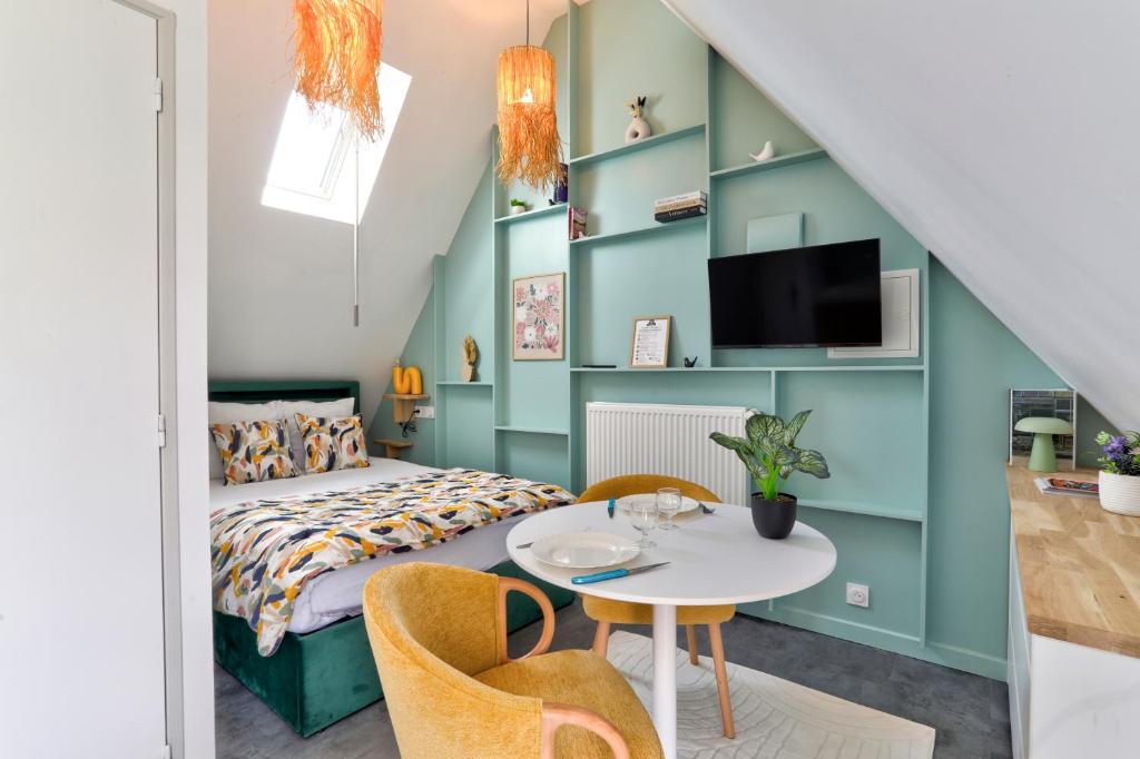 a bedroom with a bed and a table and chairs at Gîte du Merlin in Plumergat
