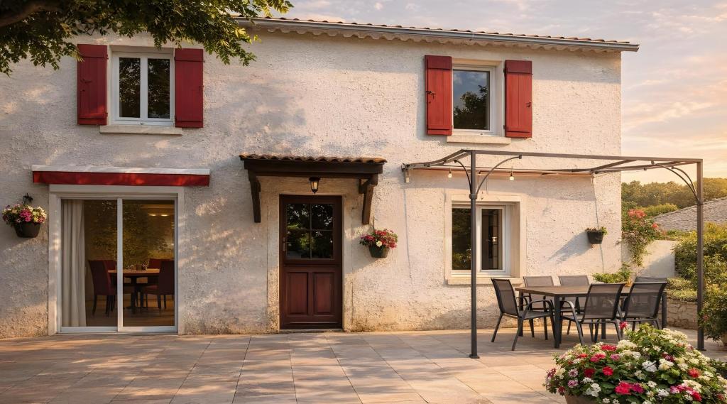 a house with a table and chairs in front of it at L'Oustau de Maître Potager in Valréas