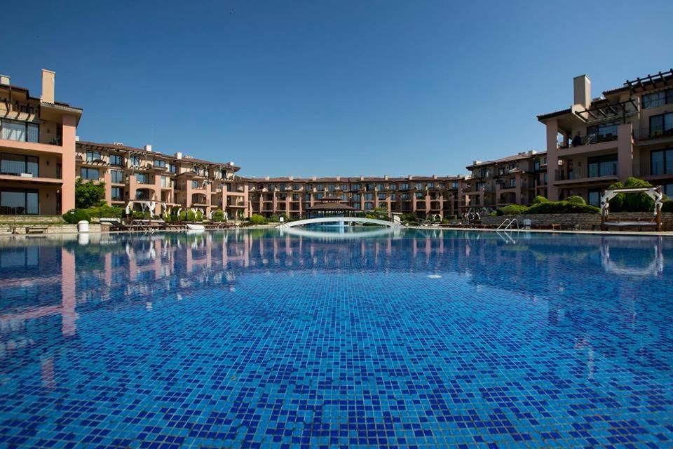 a large pool of blue water in front of buildings at Kaliakria Resort in Topola