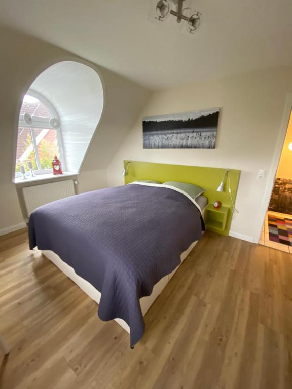 a bedroom with a bed and an arched window at HausJensen in Niebüll