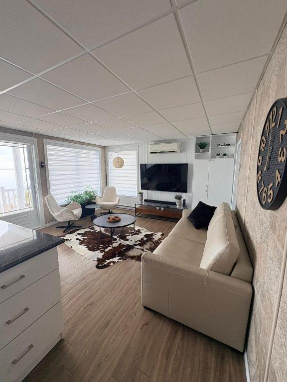 ein Wohnzimmer mit Sofa und Tisch in der Unterkunft Azura in Roberval