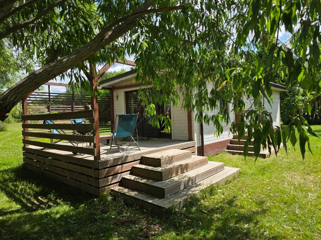 a house with a porch with a chair sitting on it at Resort Marina Suchacz in Suchacz