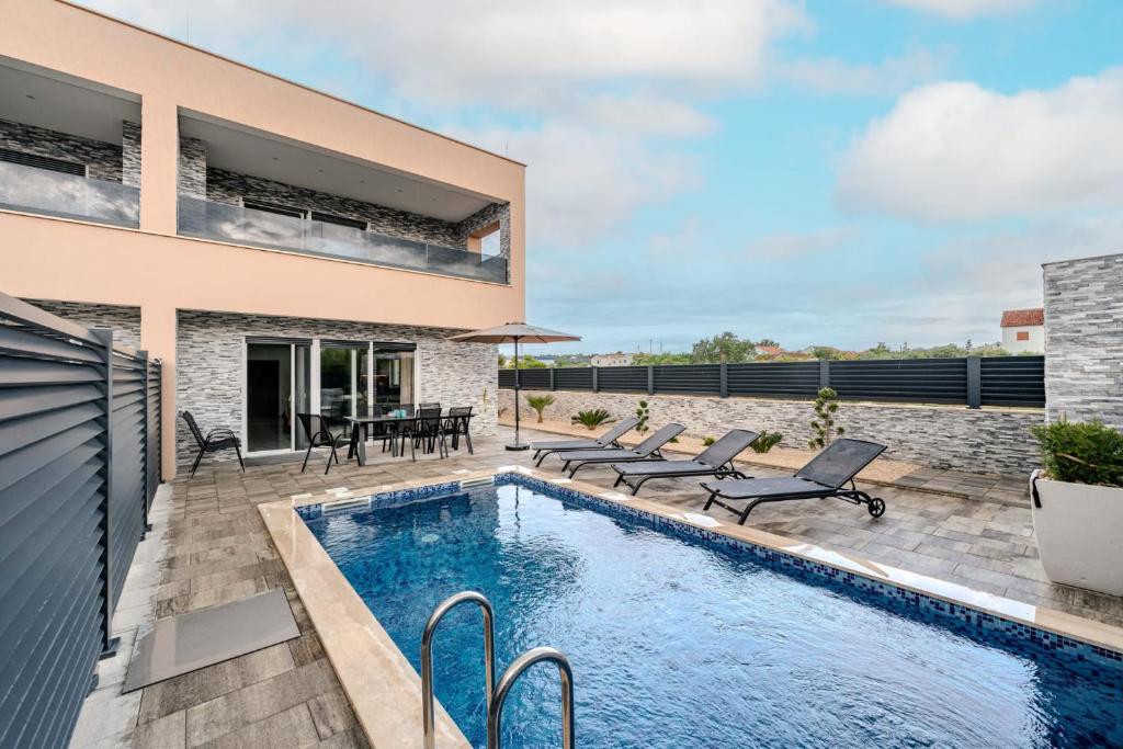 a backyard with a swimming pool and a house at Villa Lukas in Nin