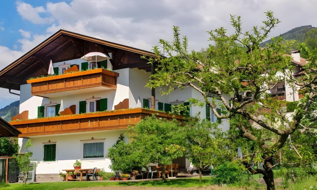 a building with a balcony and a tree at Haus Bernhard in Schenna