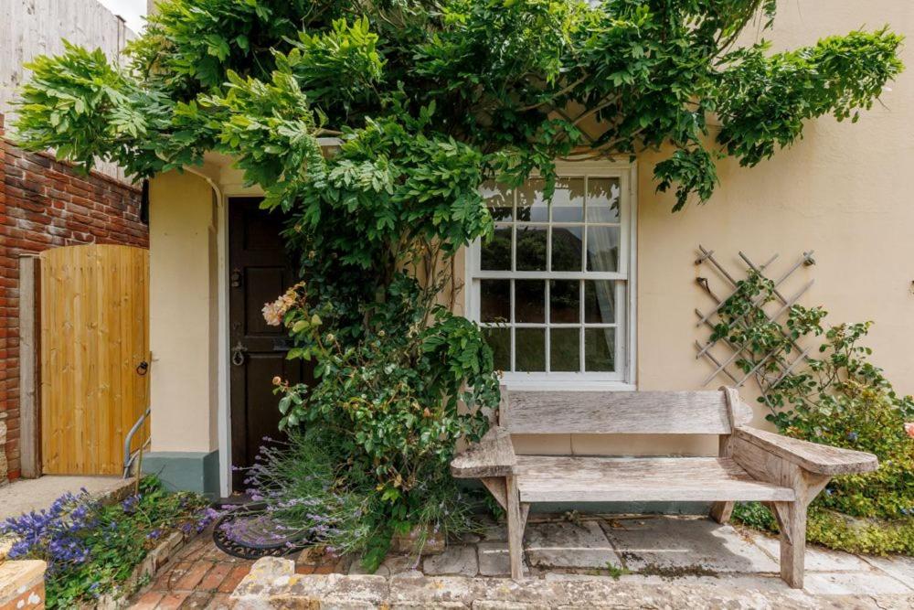 a wooden bench sitting in front of a window at Westport Cottage in Wareham
