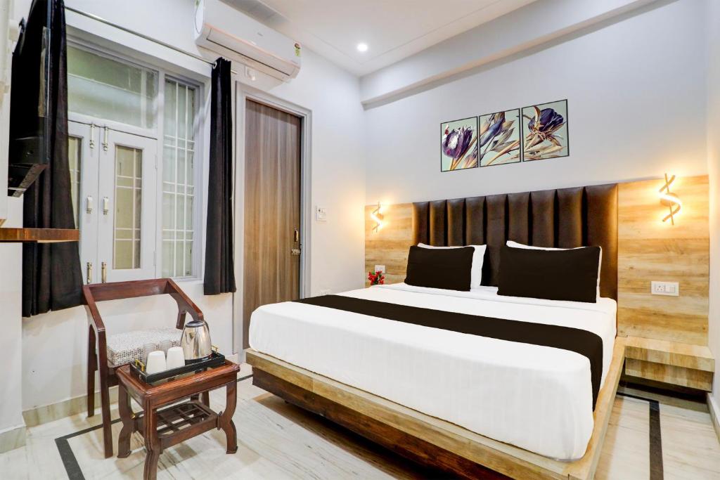 a bedroom with a large bed and a chair at Super Hotel O Gold Inn in Rohtak