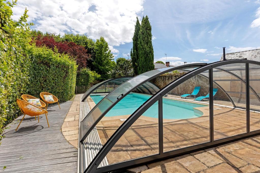 a glass bridge over a swimming pool in a yard at Maison D'hôtes Saint-Gildas in Beaufort-en-Vallée