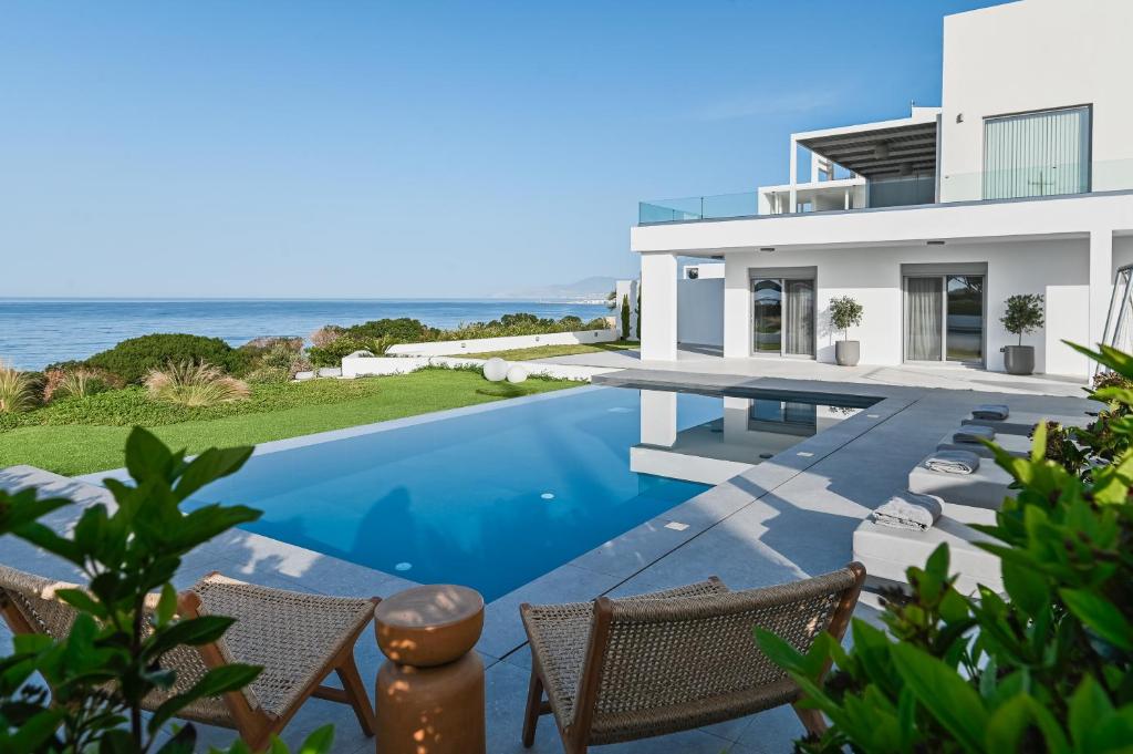 a house with a swimming pool and the ocean at Nouvelle Villa in Ierapetra