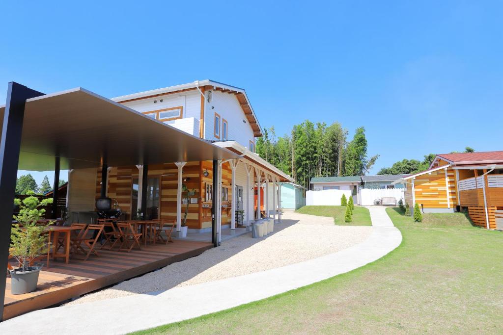 a building with a patio with tables in a yard at ヌックベル in Kumamoto