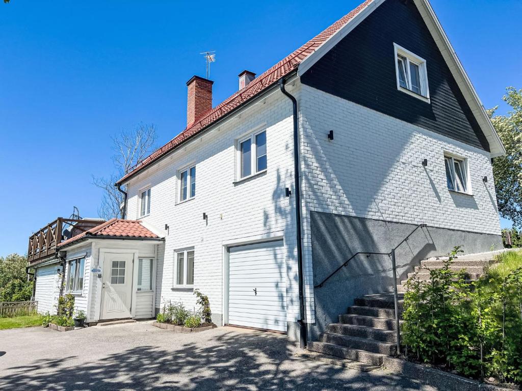 a white house with a black roof at Apartment Stadsro by Interhome in Vimmerby