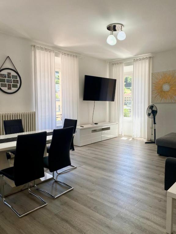 a living room with a table and a flat screen tv at Montebello in Bellinzona