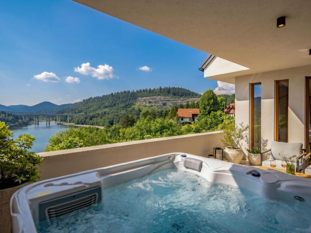 a hot tub on the balcony of a house with a view at Villa Orso by Interhome in Fužine