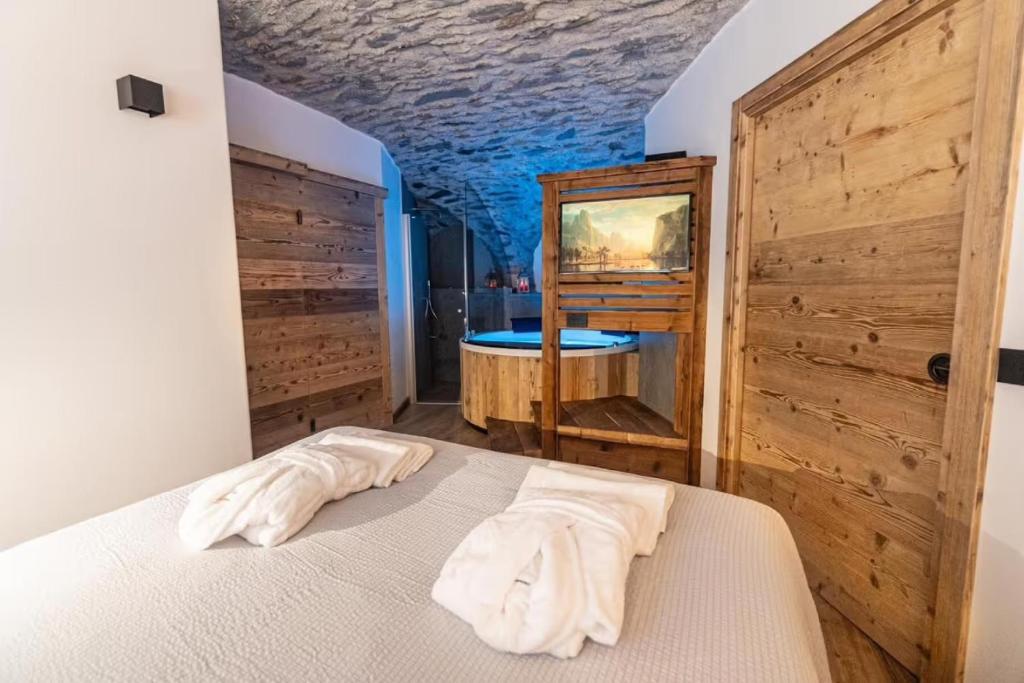 a bedroom with a bed and a tub at Giuly's Home Luxury in Bormio