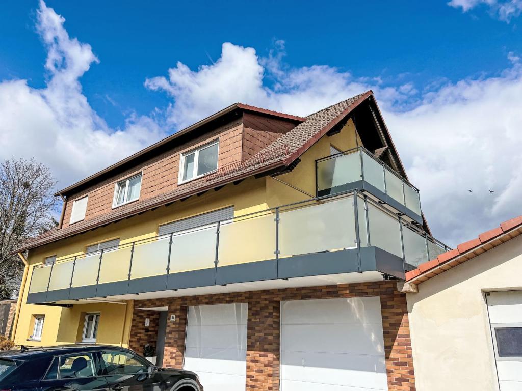 a house with a balcony on top of it at Apartment Panoramablick Rhön by Interhome in Sandberg