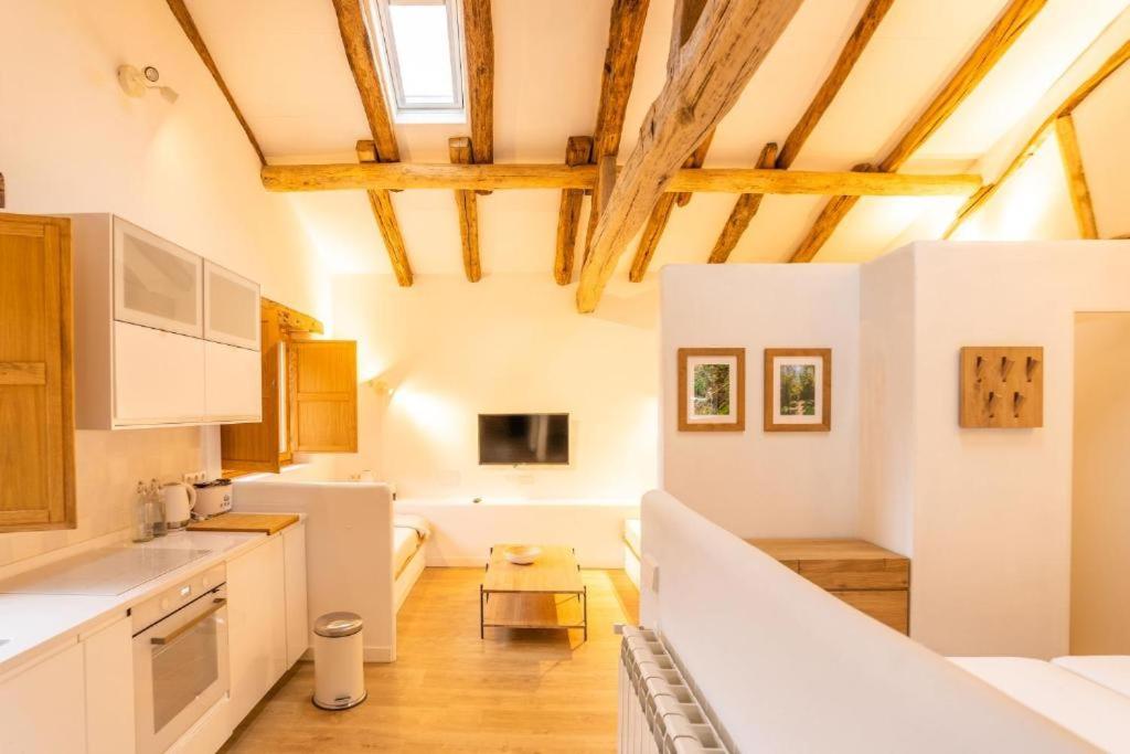 a kitchen with white appliances and wooden ceilings at La Cueva Rural Boutique Villa in La Focella