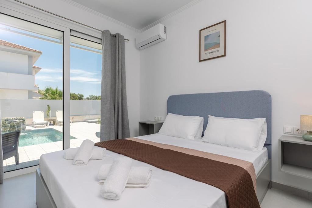 a bedroom with a bed and a view of a pool at Villa Vibella in Laganas