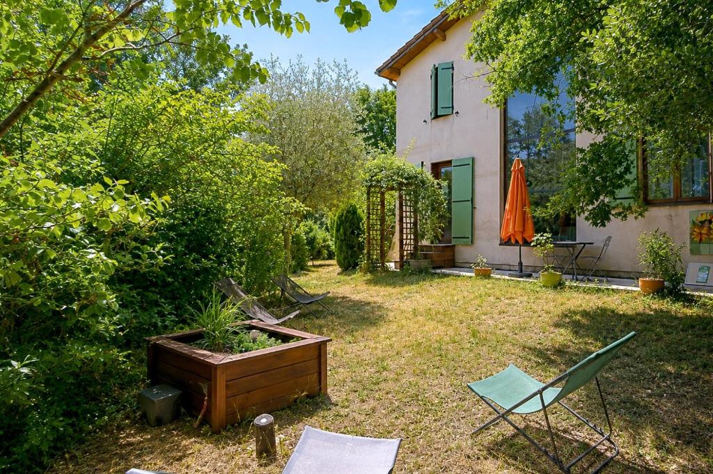a yard with a table and a chair and a house at Villa Tromelin in Bouc-Bel-Air