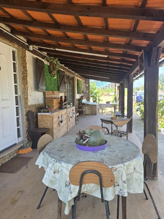 a patio with a table and chairs and a kitchen at Quinta Real Kiwibee in Barrô